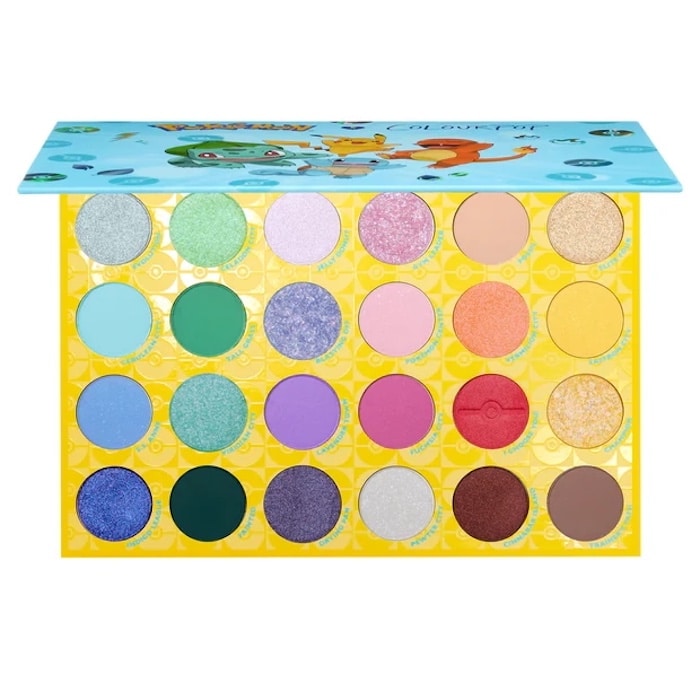An open eyeshadow palette with twenty bright colors arranged in four rows of five, featuring a blue lid with Pokémon characters and a vivid yellow base decorated with Poké Ball patterns—a must-have for fans of vibrant fashion.