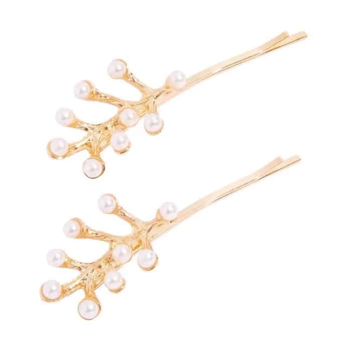 Two gold hairpins shaped like branches, each adorned with small white pearls at the tips, create an elegant summer hair accessory, beautifully arranged on a white background.