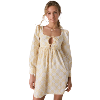 A woman wears a cream and yellow patterned dress with long sleeves, a square neckline, and a keyhole cutout at the chest—an outfit inspired by The Summer I Turned Pretty—standing against a white background.